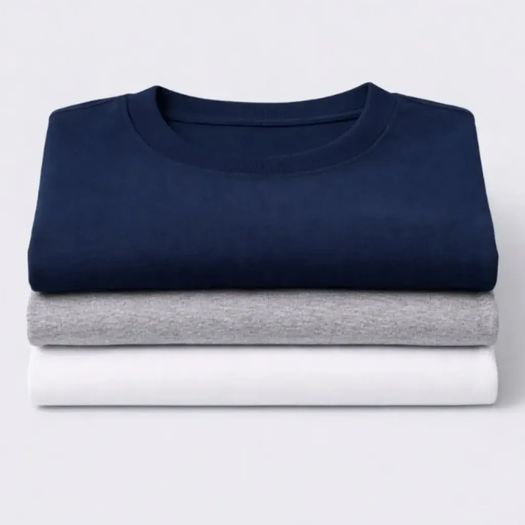 Stack of folded custom branded t-shirts in navy, gray, and white for team apparel.